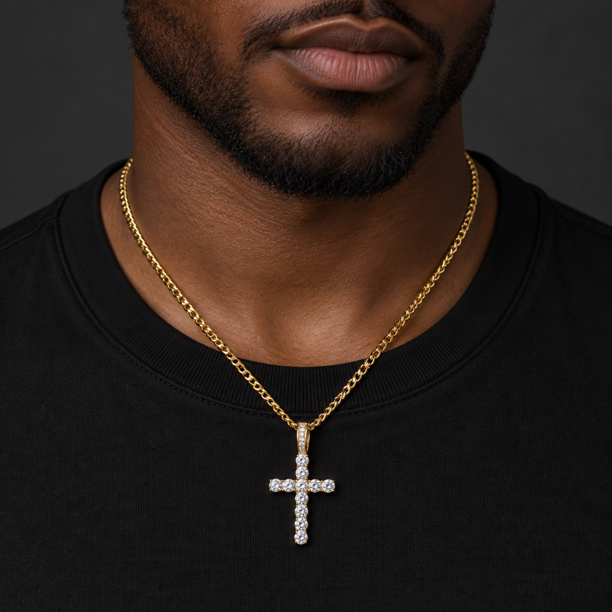 Deep brown skin model wearing gold-tone sparkling cross pendant necklace