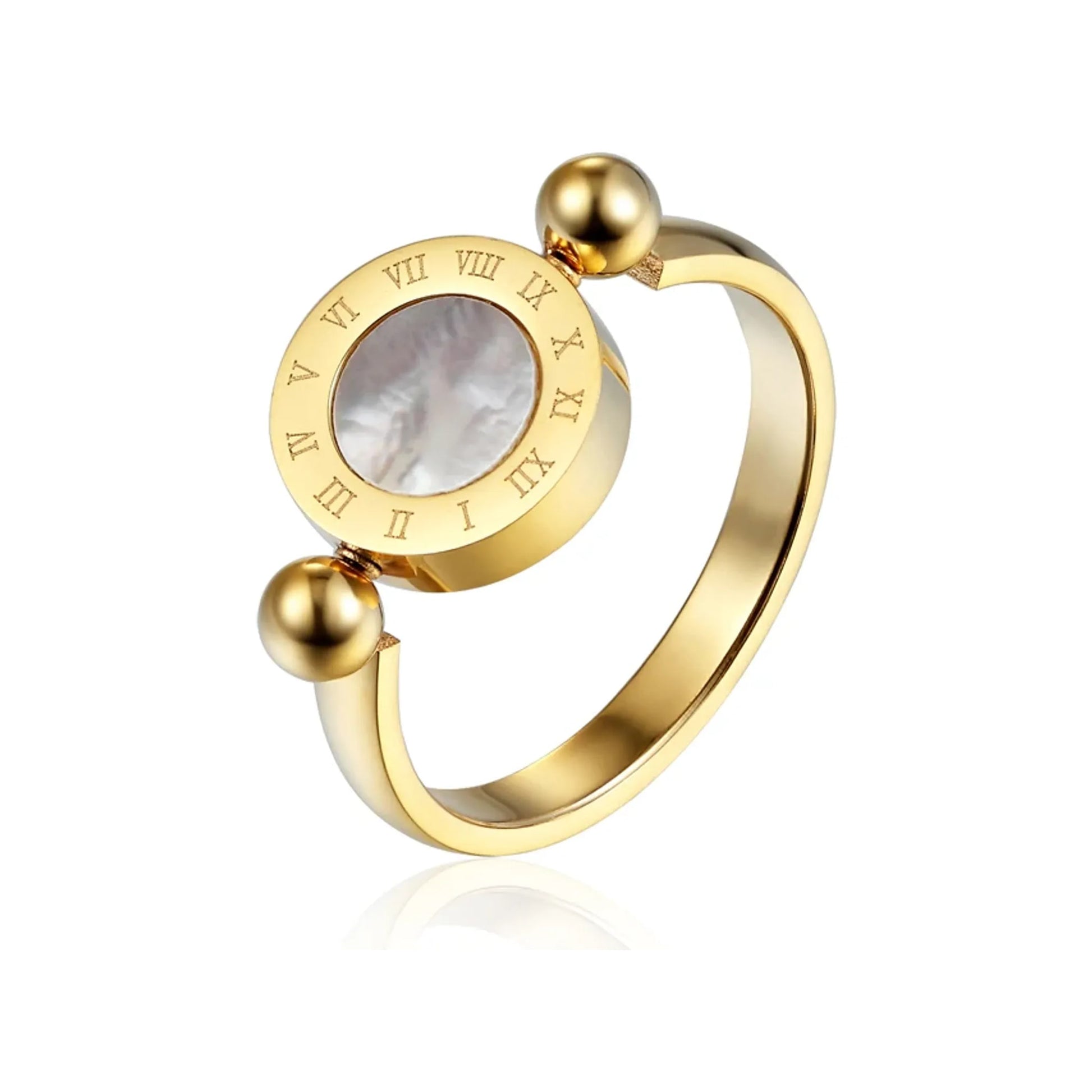 Gold-tone Roman numeral spinner ring with mother-of-pearl inset on a white reflective surface