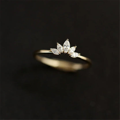 Gold-tone marquise crystal crown ring centered with a soft blurred background