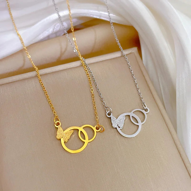 Gold-tone and silver-tone interlocking ring pendants with butterflies on display