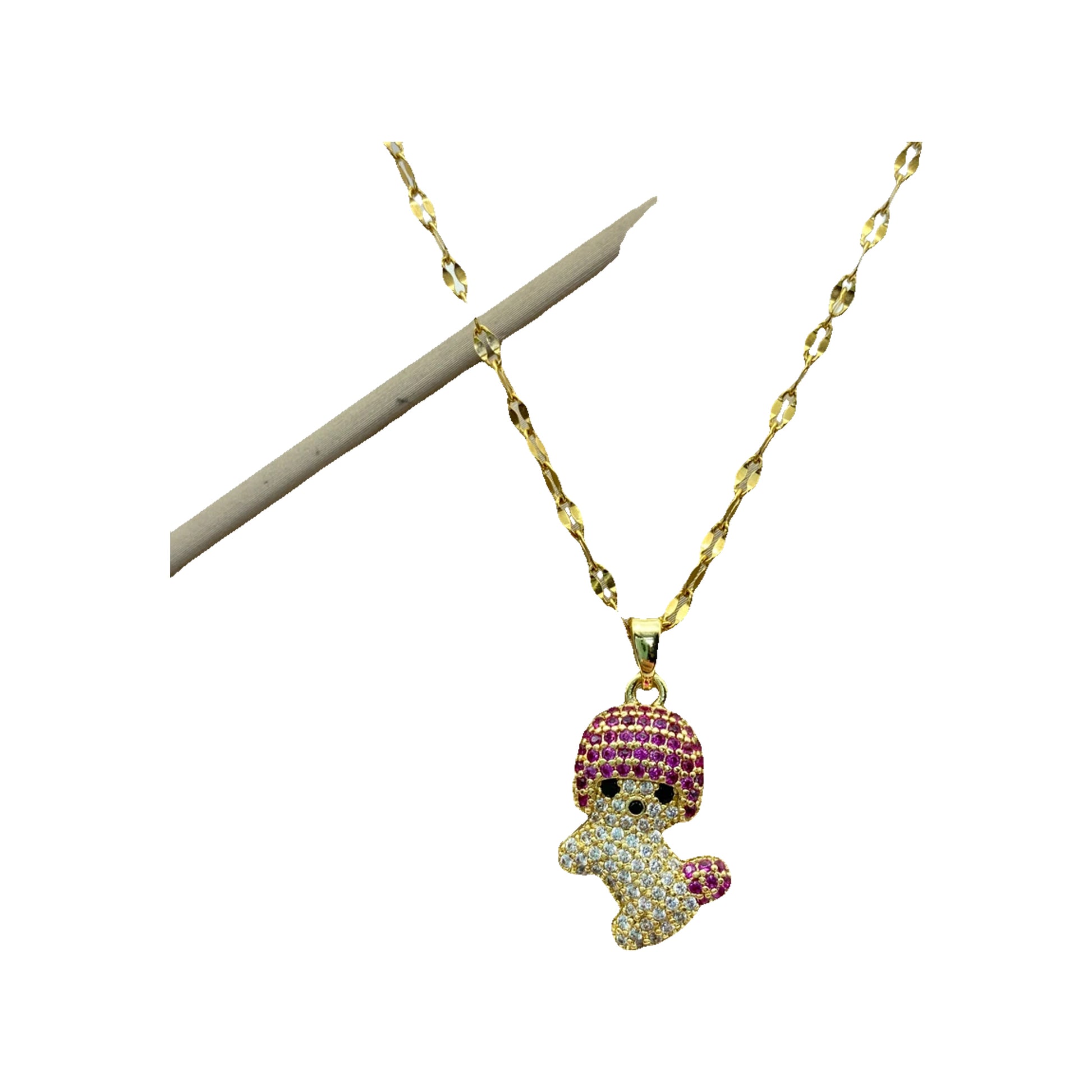 Gold-tone playful doll pendant necklace with pink and clear stones laid on a display box
