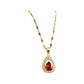 gold-tone teardrop pendant necklace held in hand to show scale