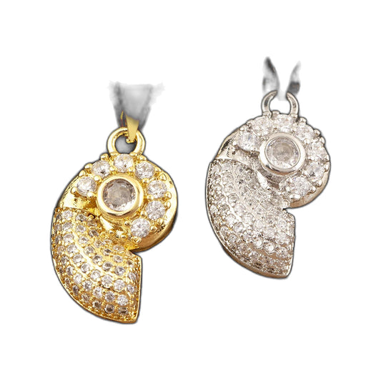 Gold-tone and silver-tone spiral shell medallion pendants displayed on a dark stone