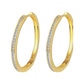 Pair of gold-tone hoop earrings with princess-cut clear stones along front edge