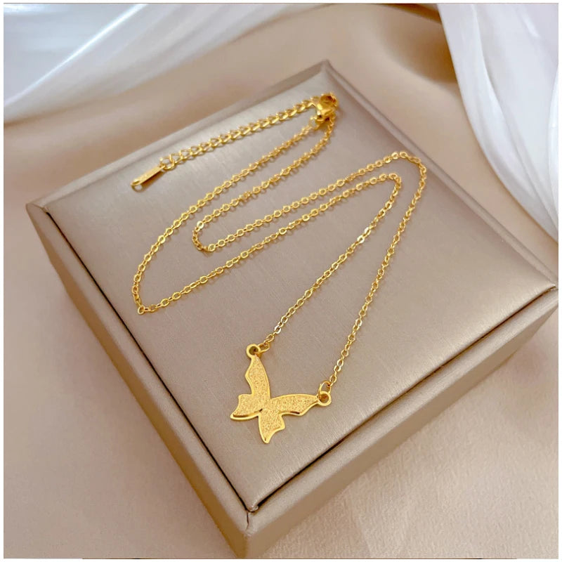 801e65a8-12cd-4644-8ac9-cec39efb265e gold-tone butterfly necklace flat on box with extension chain