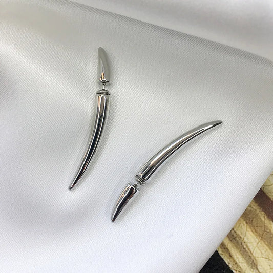 Silver-tone crescent claw long spikes arranged on white satin