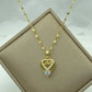 gold-tone pendant necklace with heart cutout and clear teardrop stone