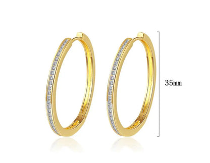 Front view of gold-tone hoop earrings showcasing slim profile and clear princess-cut stones