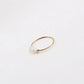 Gold-tone thin ring with irregular pearl beads photographed flat on a white backdrop