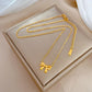 Gold-tone bow necklace with delicate chain laid on a cushioned display