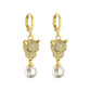Front view of gold-tone leopard head huggie earrings with dangling round pearls