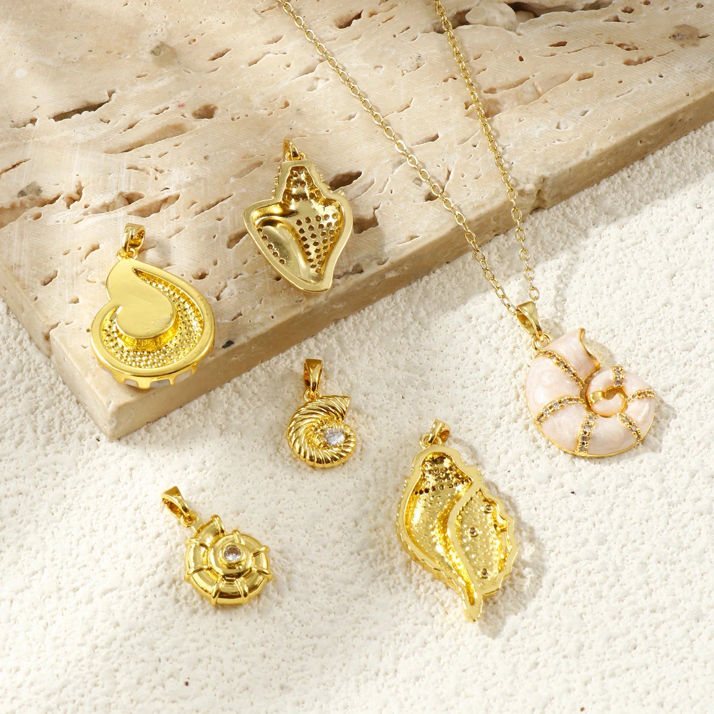 Collection of gold-tone shell pendants with one shown hanging from a fine chain
