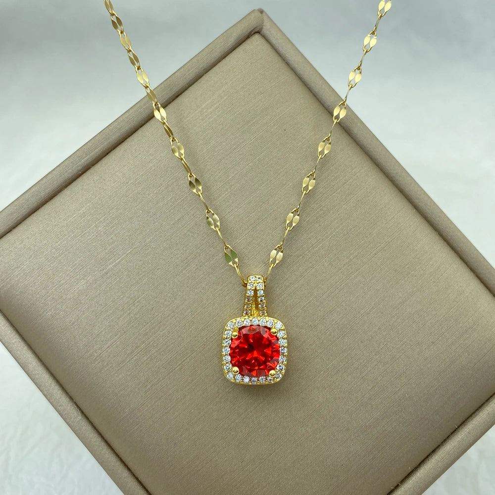 gold-tone pendant with a vibrant red cushion center stone and clear halo on a chain