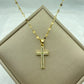 gold-tone cross pendant set with pavé clear stones on a delicate patterned chain