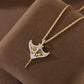 Two-tone manta ray pendant resting on brown suede display with twisted gold-tone chain