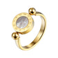 Gold-tone Roman numeral spinner ring with iridescent shell shown at three-quarter angle