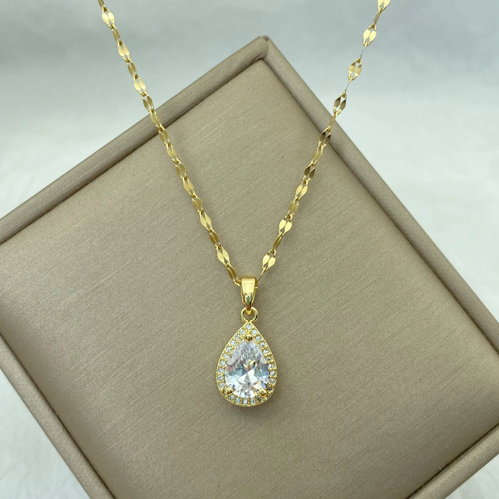 gold-tone teardrop pendant with a large clear center stone and halo on a fine chain