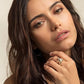 Gold-tone starfish pavé openwork ring worn on index finger held near the chin
