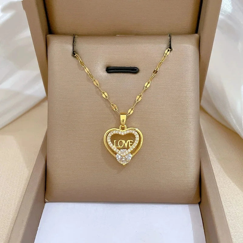 Gold-tone heart pendant with decorative openwork shown on a cushioned box display