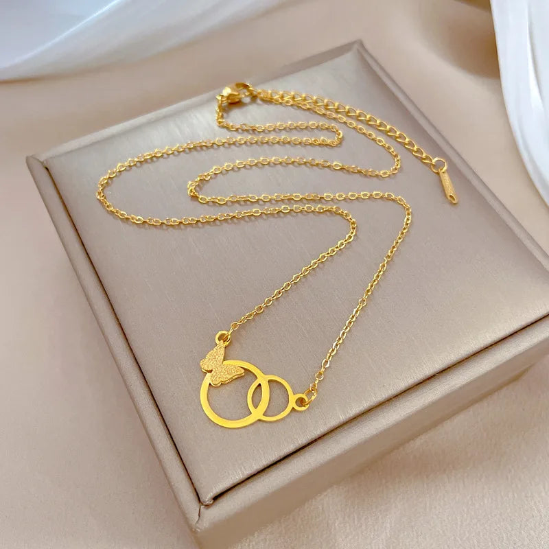 Gold-tone interlocking rings pendant necklace arranged on a gift box
