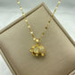 gold-tone elephant pendant encrusted with clear stones hanging from a patterned chain