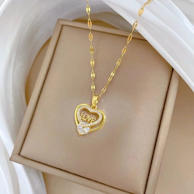 Gold-tone heart pendant on a patterned chain in a tan jewelry tray