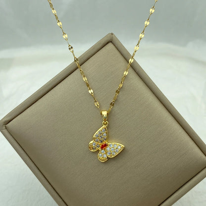 butterfly pendant necklace with clear wings and a red center displayed on a tilted beige box