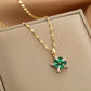 gold-tone pendant necklace with green floral cluster and baguette clear accents