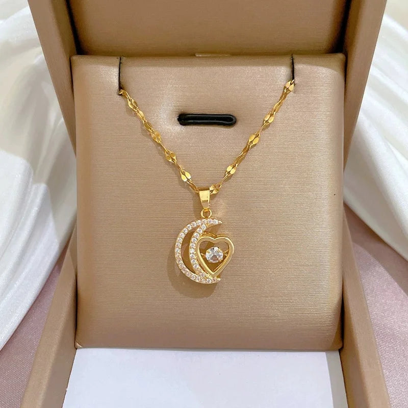 Heart-and-moon gold-tone pendant displayed on a beige jewelry box insert
