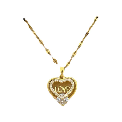 Gold-tone heart pendant with decorative openwork shown on a cushioned box display