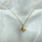 gold-tone butterfly pendant necklace worn at the collarbone on a display bust