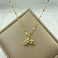 Gold-tone whale-tail pendant necklace accented with clear stones on a patterned chain