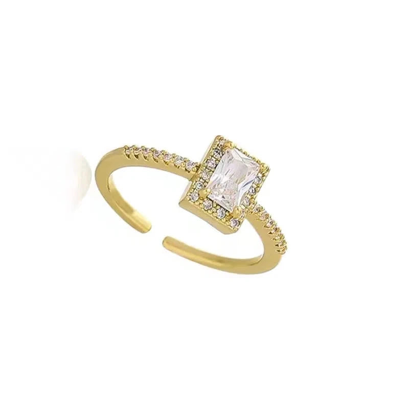 Gold-tone adjustable open ring with a square halo and clear center stone
