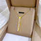 260be645-fe05-4a39-8c15-9aa458a1c6a5 gold-tone vertical bar pendant with pearlescent inlay on beige display cushion