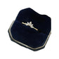 Ring nestled in a navy velvet jewelry box with cream-trimmed edges