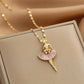 gold-tone ballerina pendant necklace with pink fan skirt displayed on a jewelry box