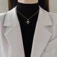 Gold-tone airplane pendant necklace worn at the collarbone