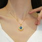 Gold-tone eye pendant necklace worn at the base of the throat with delicate chain