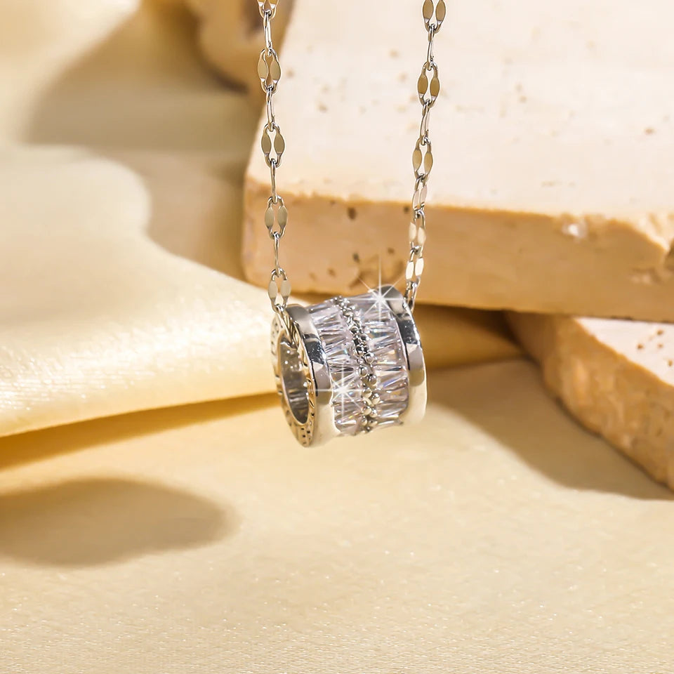 Silver-tone version of the barrel pendant necklace with clear baguette stones on a patterned chain, close-up view.