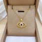 Decorative eye-motif gold-tone pendant with radiating fringe presented in a box