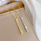 0cc7ccda-c559-4209-ba1e-e62ce5295179 gold-tone and silver-tone vertical bar pendants with pearlescent inlay on display