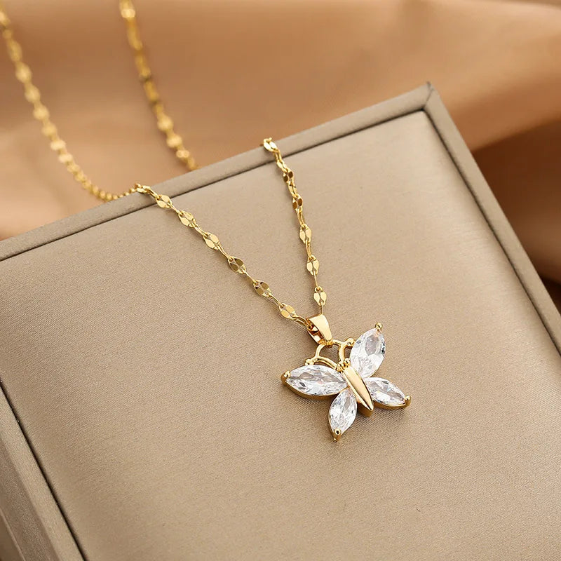 butterfly pendant necklace with four clear marquise wings shown draped on a beige display