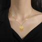 Gold-tone ornate heart pendant necklace with dangling charms worn at the collarbone