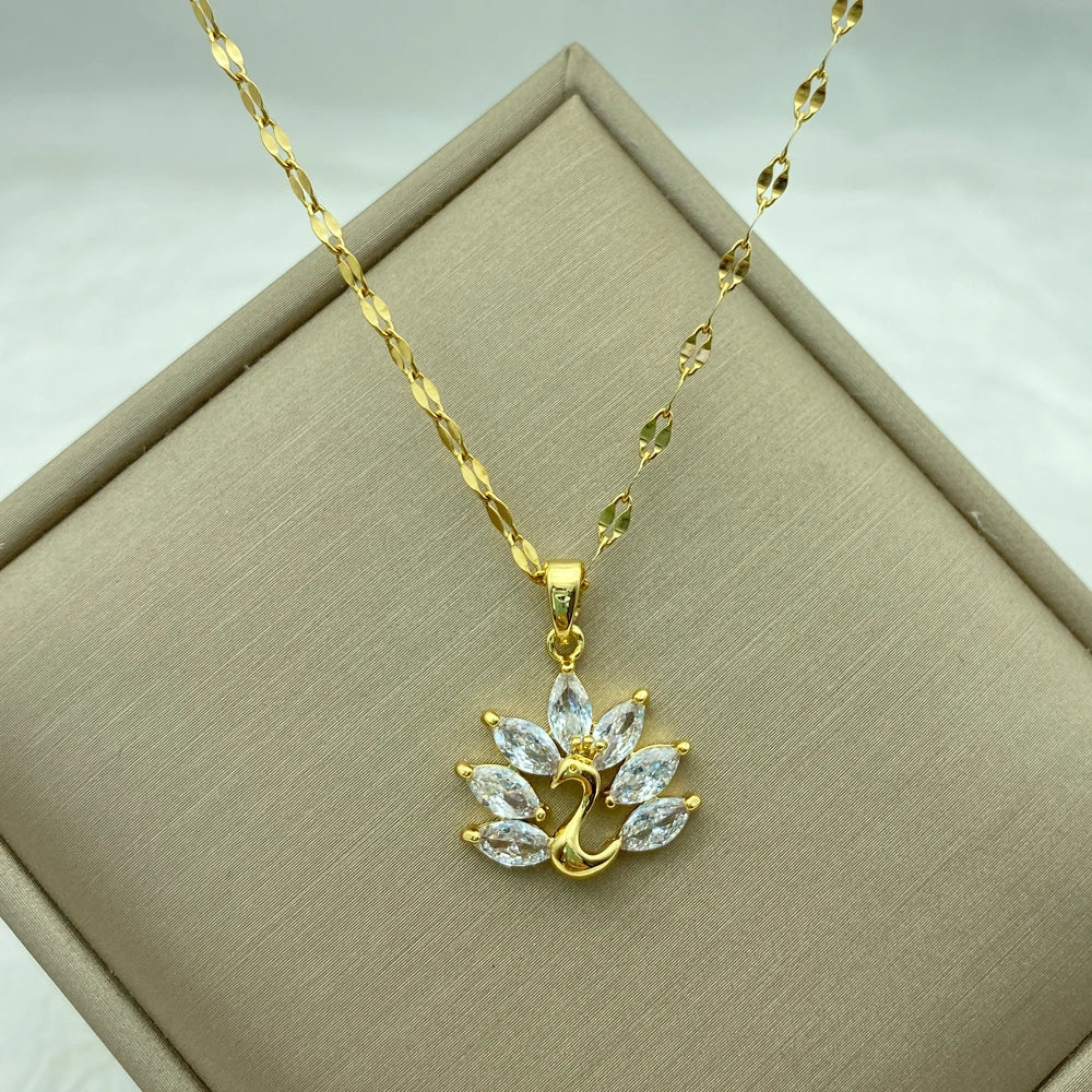 gold-tone swan pendant necklace with marquise clear wings displayed on a box