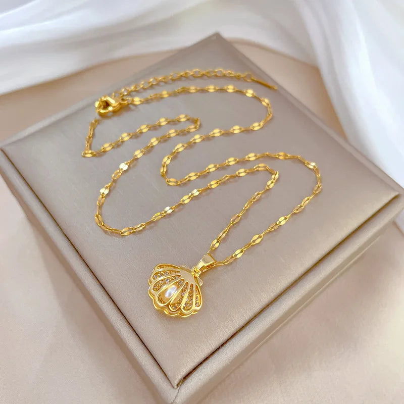 Gold-tone shell pendant necklace arranged on satin and a neutral box for a styled flat lay