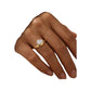 hand wearing a gold-tone pear-cut solitaire ring on the middle finger