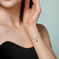 Gold-tone Madonna glow-in-the-dark dangle charm worn at the wrist on a thin bracelet