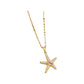 Gold-tone starfish pendant necklace with pink center stone on display