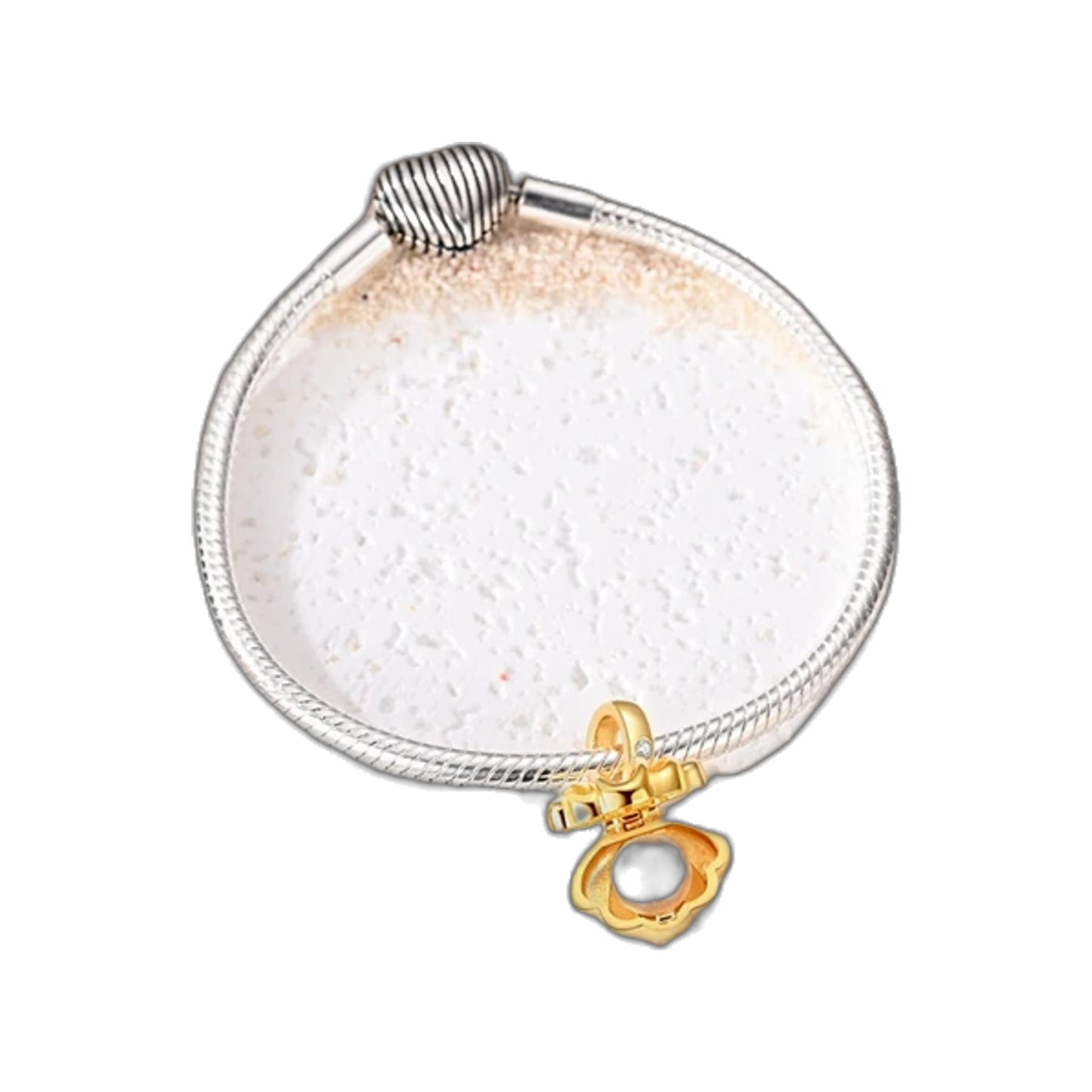 Gold-tone clamshell dangle charm with pearl on a bracelet and loose on sand with shells