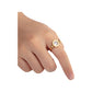 Gold-tone Roman numeral spinner ring worn on the index finger against a page background